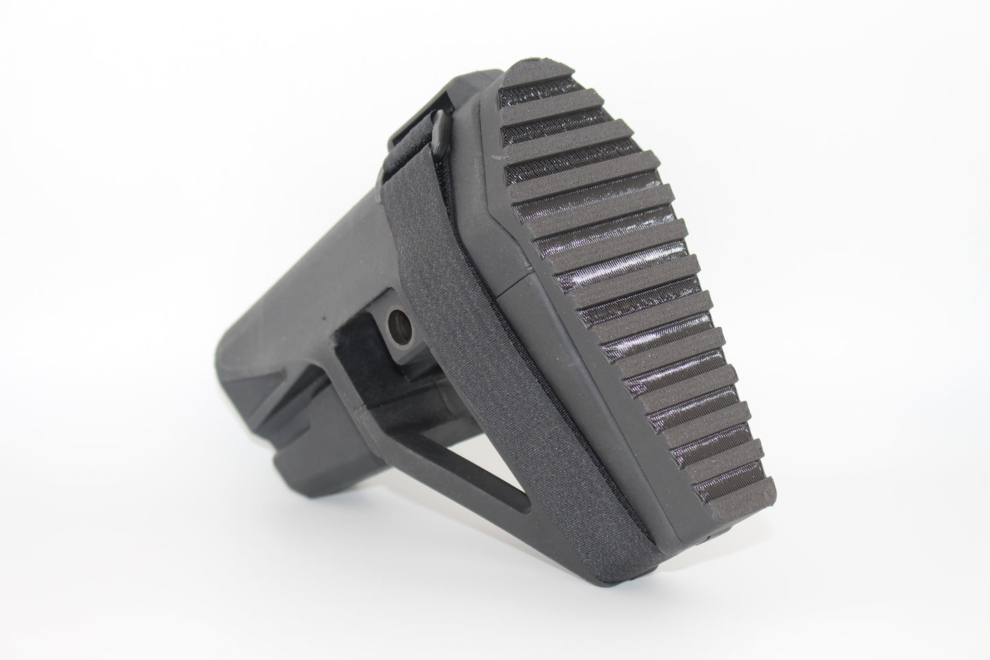 Angled view of black SBA5 full-length Devoid plug installed in the SBA5 brace, showing textured grip surface and integrated SB logo clip retention mechanism, on a light grey background.