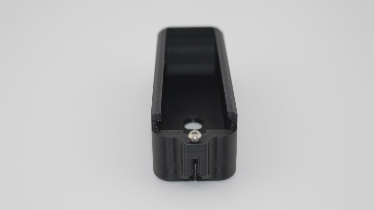Front view of black +3 round magazine extension designed for MDT Polymer AICS magazines, showing tall rectangular body with rounded top edges, open interior cavity and central screw hole, on light grey background.