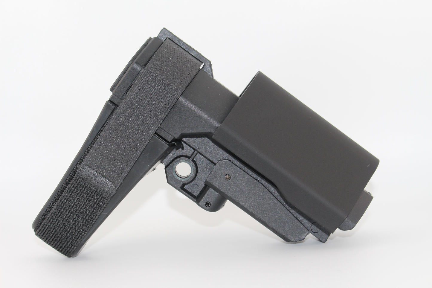 Side view of black half-size SBA3 cheek riser attached to the SBA3 brace in an elevated position, showing contoured riser with Velcro strap on a white background.