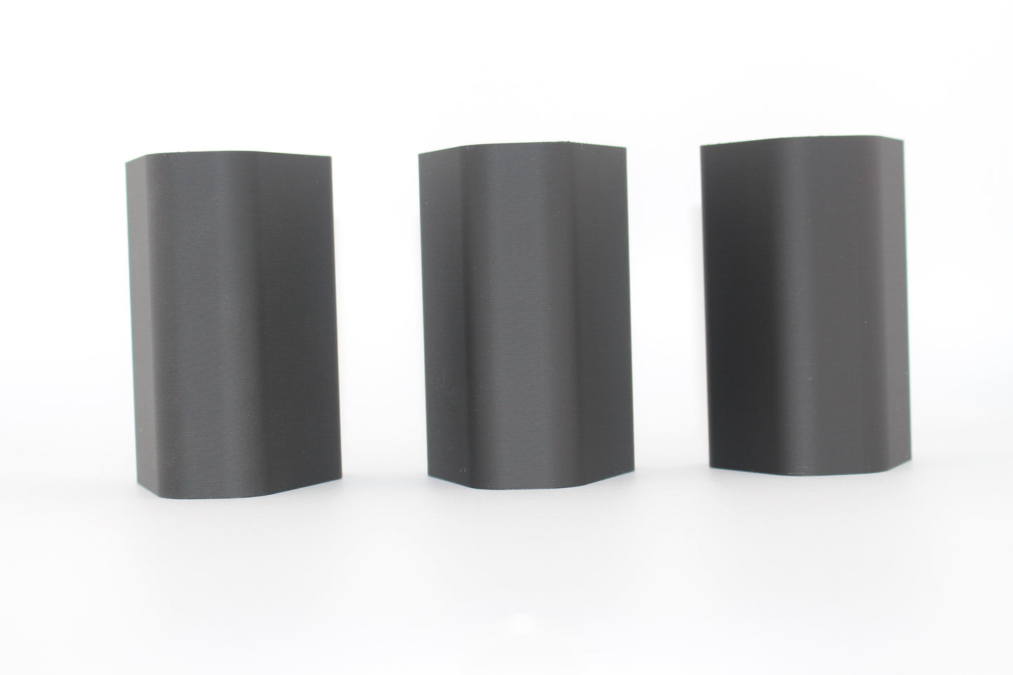 Top surfaces of three black half-size SBA3 cheek riser inserts representing 20mm, 17mm and 10mm heights, displayed upright with smooth, curved surfaces on a white background.