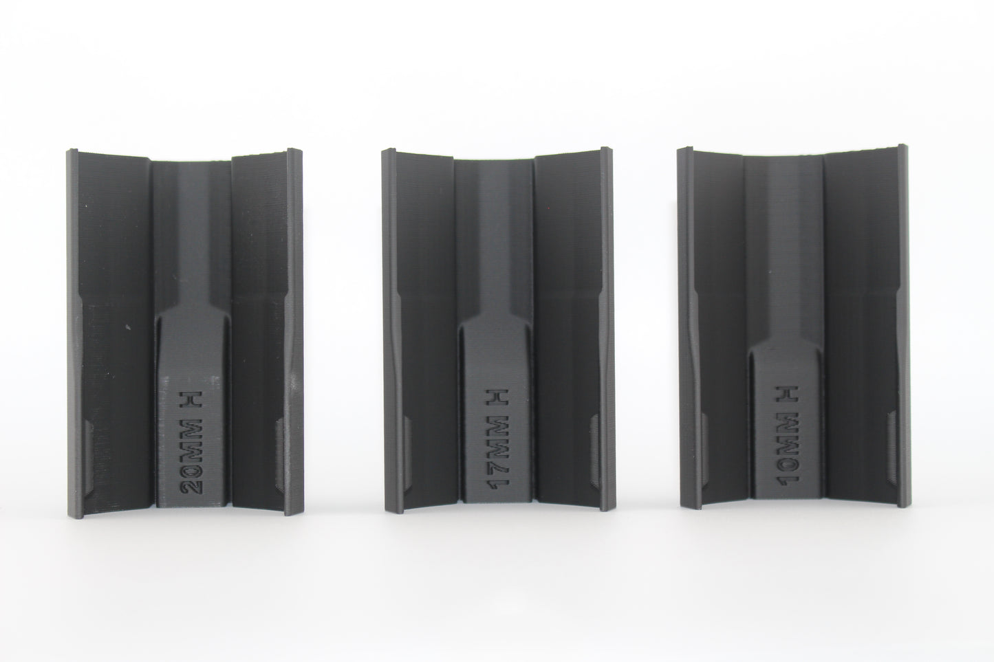 Bottom view of three black half-size SBA3 cheek riser inserts labeled 20mm, 17mm and 10mm, showing underside profiles and mounting channels, displayed on a white background.