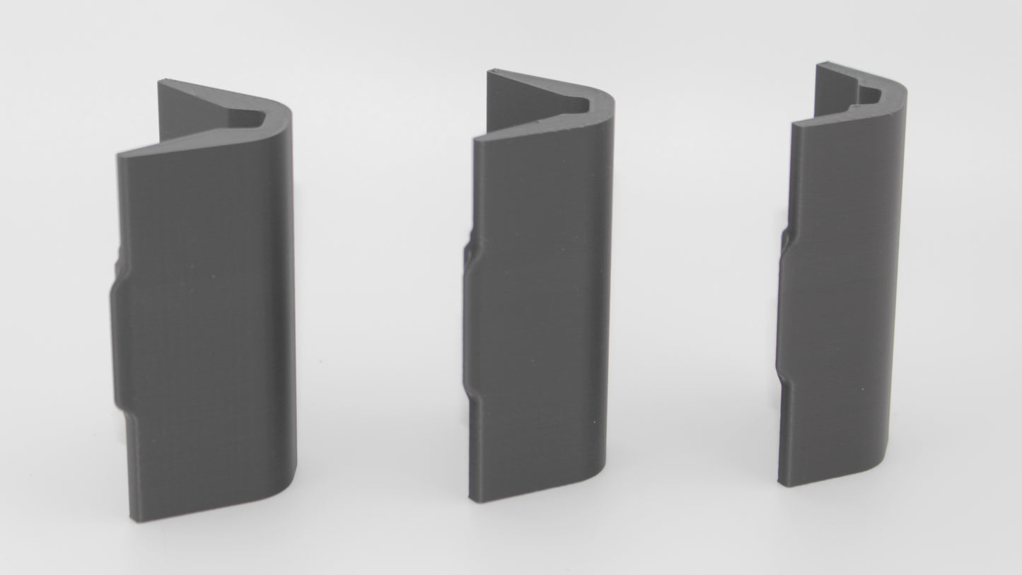 Side view of three black modular SBA4 cheek riser inserts displayed upright showing the back side with smooth texture, representing 20mm, 17mm, and 10mm heights, on a light gray background.