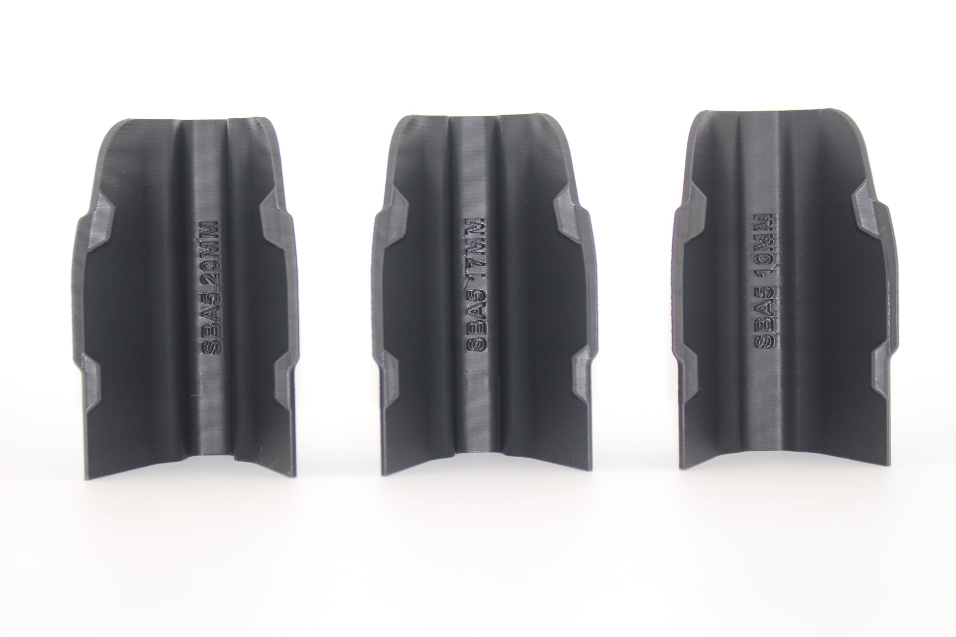 Three black SBA5 cheek riser inserts in 10mm, 17mm and 20mm heights displayed upright from bottom view on white background
