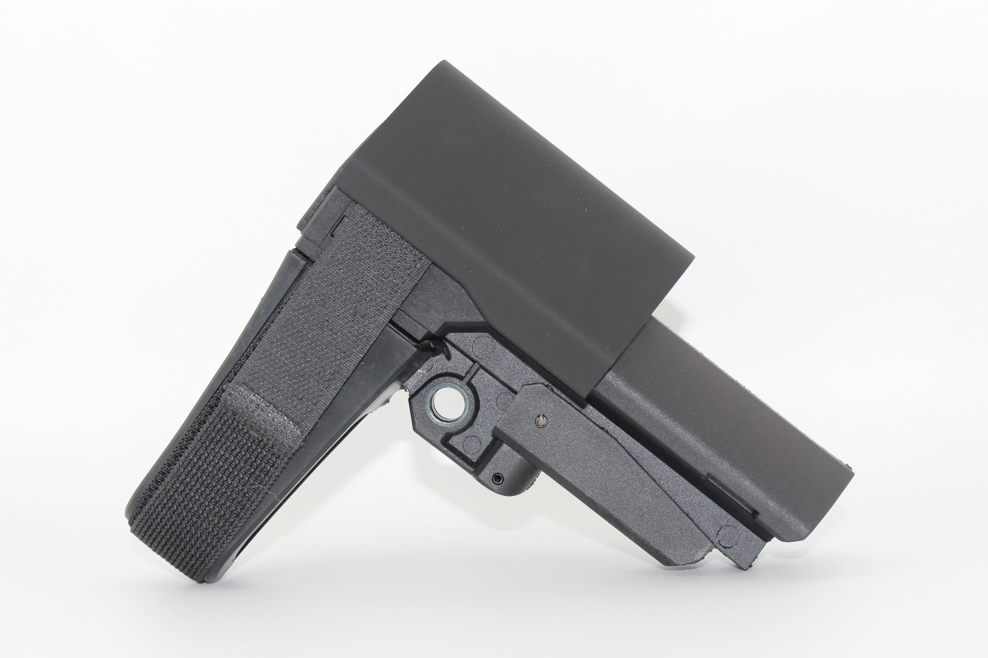 Side view of black half-size SBA3 cheek riser attached to the SBA3 brace, showing contoured riser shape and Velcro strap, displayed on a white background.