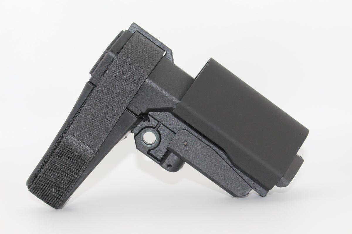Side view of black half-size SBA3 cheek riser attached to the SBA3 brace in an elevated position, showing contoured riser with Velcro strap on a white background.