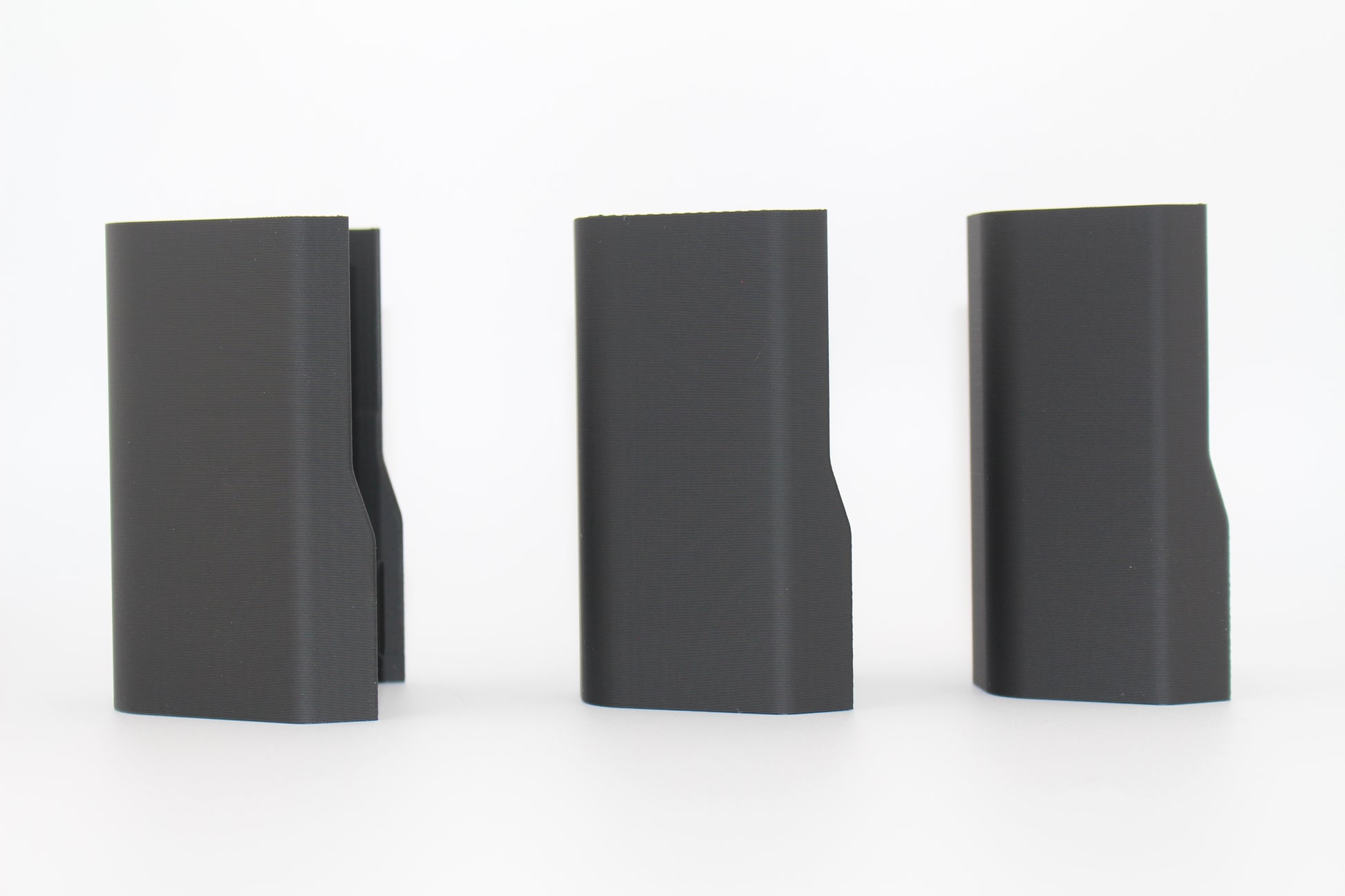 Side view of three black half-size SBA3 cheek riser inserts representing 20mm, 17mm and 10mm heights, aligned upright with contoured outer profiles, displayed on a white background.