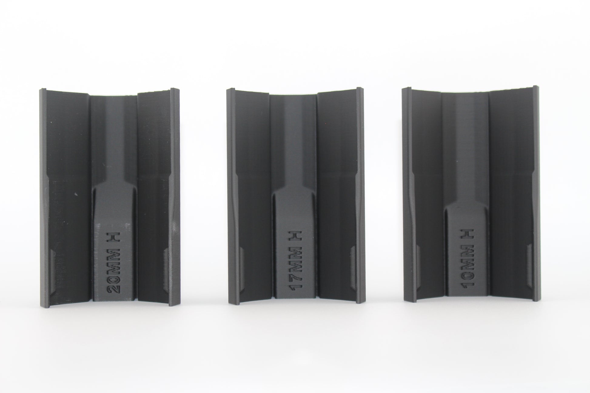 Bottom view of three black half-size SBA3 cheek riser inserts labeled 20mm, 17mm and 10mm, showing underside profiles and mounting channels, displayed on a white background.