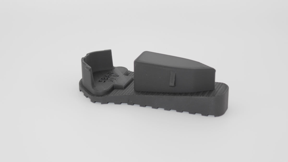 Side view of black SBA4 full-length Devoid plug showing contoured top wedge and integrated ribbed base, displayed on a light grey background.